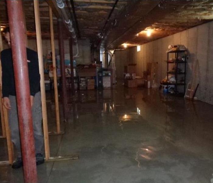 A man standing in a wet basement with standing water