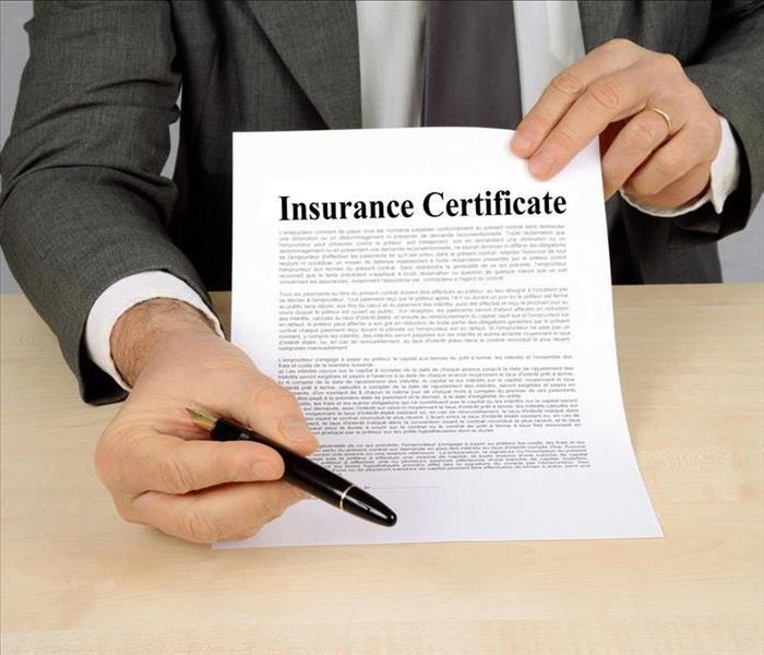 salesman holding up insurance policy form